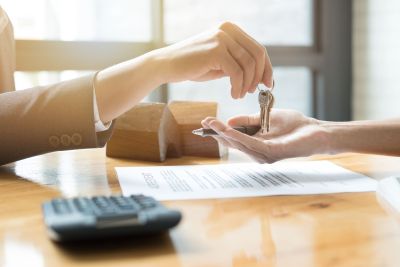 Handing house keys to woman 